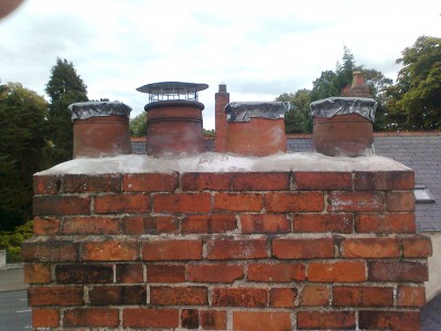 Four pot chimney with lead caps and a Chinese Man's Hat - to let out the smoke but block entry by rain or birds. Fitted by Roof Repairs Belfast, Northern Ireland - phone 028 90309949 Four pot chimney with lead caps and a Chinese Man's Hat - to let out the smoke but block entry by rain or birds. Fitted by Roof Repairs Belfast, Northern Ireland - phone 028 90309949